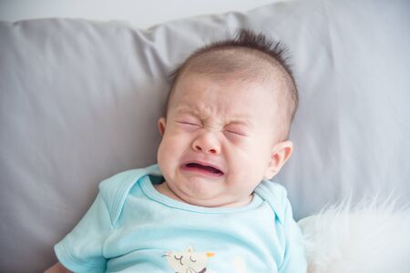 Closeup shot of little asian infant cryingの写真素材
