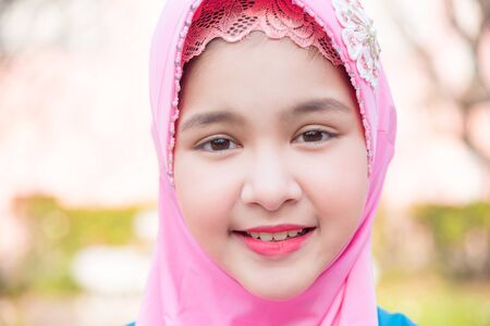 Closeup shot of young female muslim girl face wearing pink hijabの写真素材