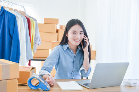 Female startup small business owner working with notebook computer at office. Online selling. E-commerce.の写真素材