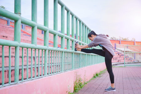 Beautiful asian woman in sportswear stretching before run outdoors in the city.の写真素材