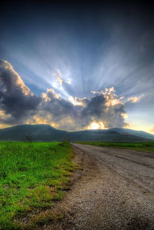 Sunrays through clouds in late afternoonの写真素材