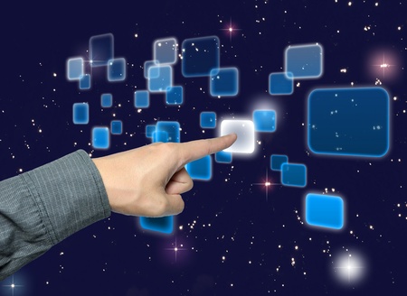 hand pushing a button on a touch screen interface under starry night skyの写真素材