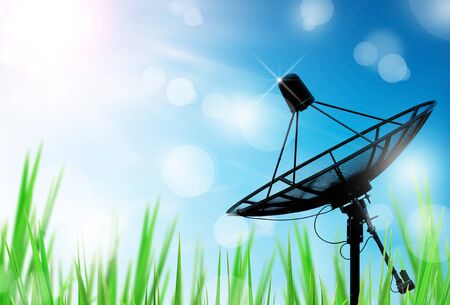 satellite dish antennas in field under sky and light reflect in morningの写真素材