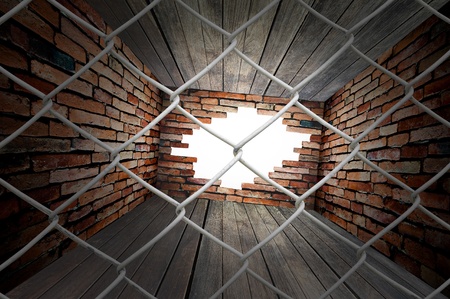Chain link fence see hole on wall in empty roomの写真素材