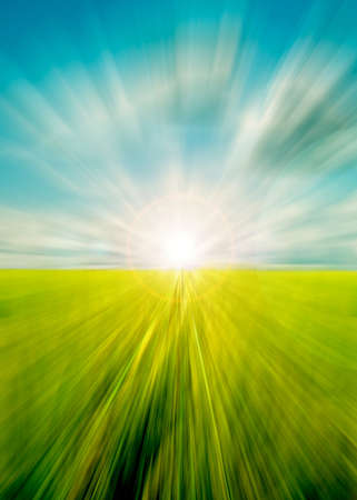 Abstract motion blurred meadow and sky with sunの写真素材