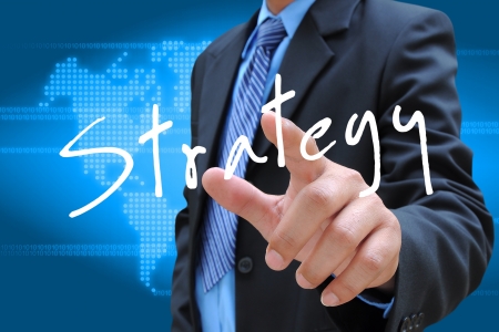 businessman hand pushing strategy button on a touch screen interfaceの写真素材