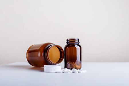 Large and small Dietary supplement bottles set on a white background.の写真素材