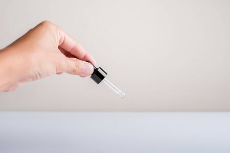 Close up of hands used serum dropping on white background.の写真素材