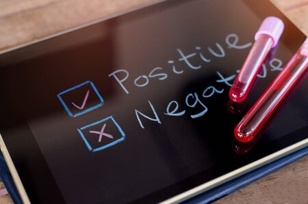 Blood collection tube on a tablet with choose Negative or Positive. Coronavirus Blood test.の写真素材