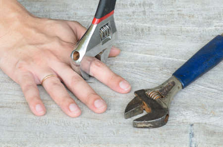 Assembly Hand (focus between wrench and finger)の写真素材