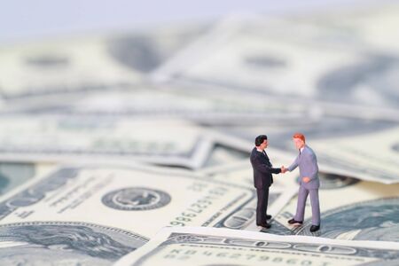 Miniature people: businessman shaking hand with partner (Financial and Business competition concept)の写真素材