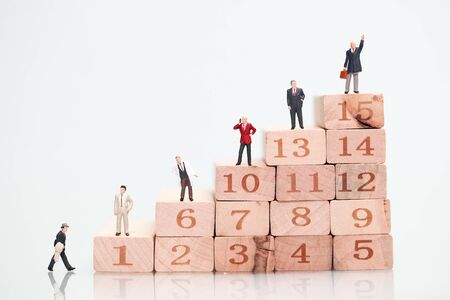 Miniature people: businessman standing on wood block stacking, Financial and Business growth concept using as backgroundの写真素材