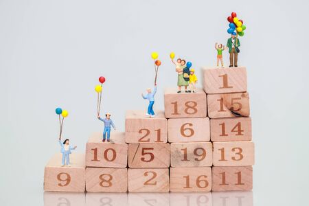 Miniature people: traveler standing on wood block stacking, Financial and Business growth concept using as backgroundの写真素材