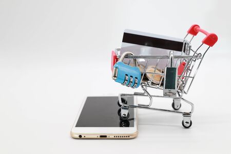 security lock and password protection on trolley with credit card and money on smart phone (this image for security technology concept)の写真素材