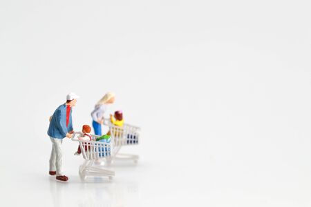 Miniature people: shopper walking on white background as payment and purchase online (e-commerce and shopping concept)の写真素材