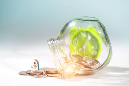 Miniature people: trolley on money and timer beside, idea for race against time and beat the clock to be a winner in market (Financial and Business competition concept)の写真素材