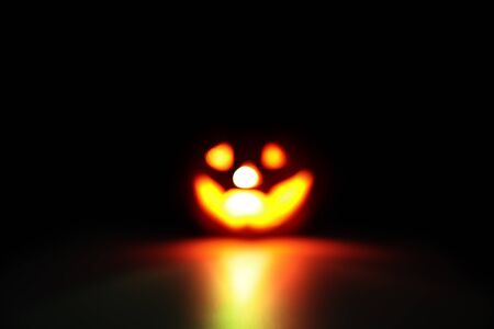 blurred image of halloween pumpkin on black background with dark filterの写真素材
