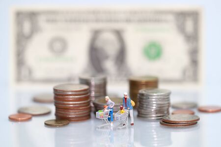 Miniature people: shopper walking beside money, business using as backgroundの写真素材
