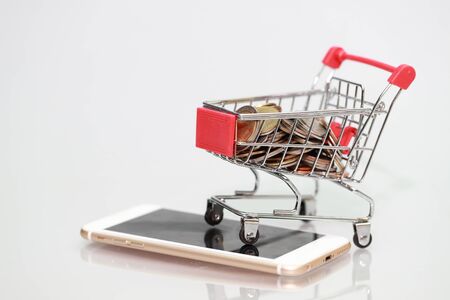 trolley with coins and credit cards on smart phone, idea for shopping and online payment using as business backgroundの写真素材