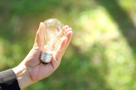 businesswoman holding electric glass bulb, idea for business innovation and inspiration concept using as backgroundの写真素材