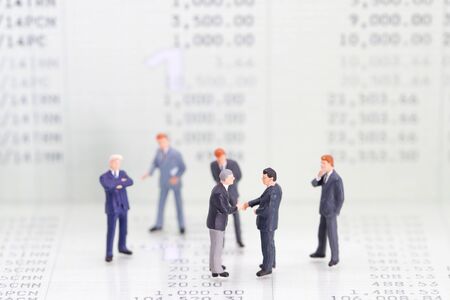 Miniature people: a group of businessman standing on book bank (this image for financial and business competition concept)の写真素材