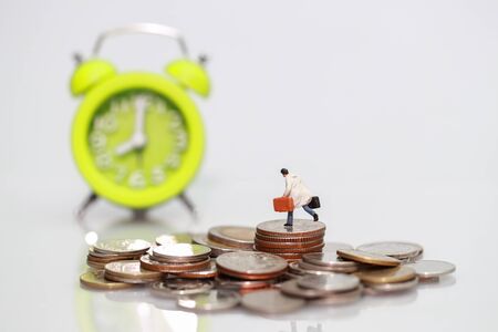Miniature people: businessman standing on stacking coins , Financial and Business competition concept using as backgroundの写真素材