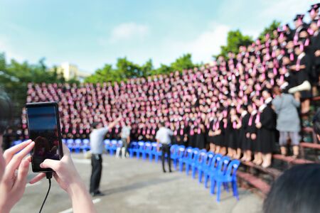 asian woman are photographing the crowd with cell phoneの写真素材