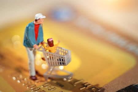 Miniature people: shopper walking on credit card as payment and purchase online (e-commerce and shopping concept)の写真素材