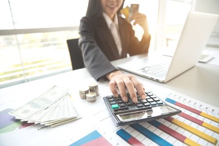 businesswoman using laptop computer while working on company summary report with graphの写真素材