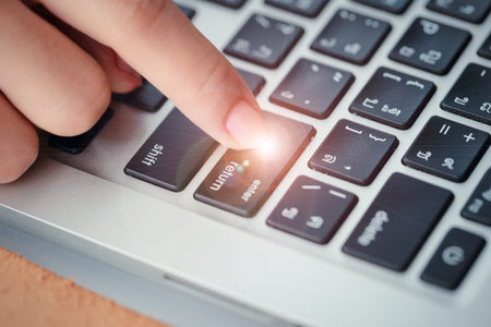 human hand press enter or confirm button on computer keyboard