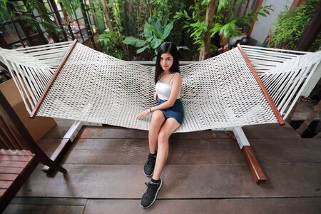 portrait of beautiful and cute asian woman lying in a hammockの写真素材