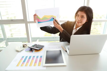 businesswoman showing company profit with graph in meeting roomの写真素材