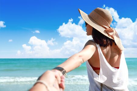 portrait of a couple holding hand on the beach with nice blue sky (this image for holiday vacation concept)の写真素材