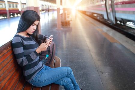 young traveler woman with backpack using smart phone during traveling on holidayの写真素材