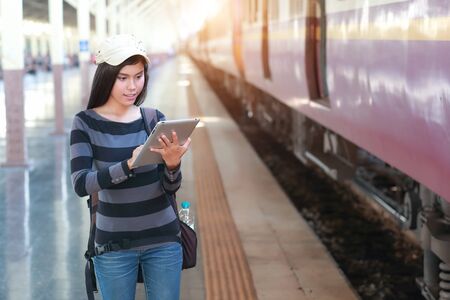young traveler woman with backpack using tablet during traveling on holidayの写真素材
