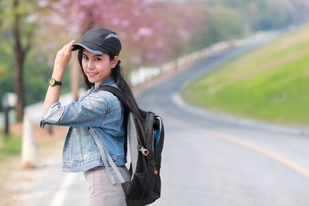Young asian traveler with backpack looking direction on the road while traveling during holiday vacationの写真素材