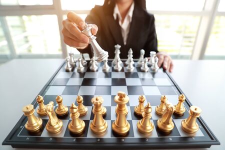 Businesswoman playing chess board game idea of management strategy and leadership conceptの写真素材