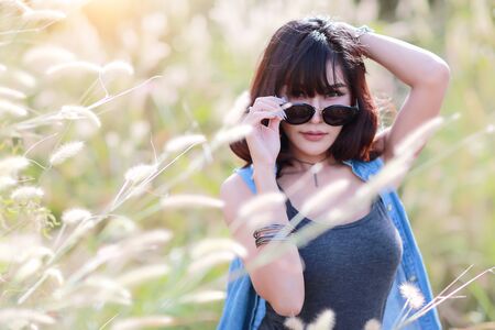 young and cute girl having a happy time and enoying amoung grass field in natureの写真素材