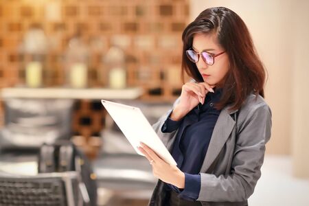 beautiful businesswoman portrait with glasses using tablet (this image for business and technology background concept)の写真素材