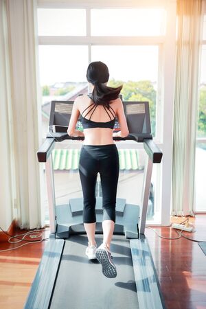 young healthy sport woman running or walking on exercise machine in gym (workout concept)の写真素材