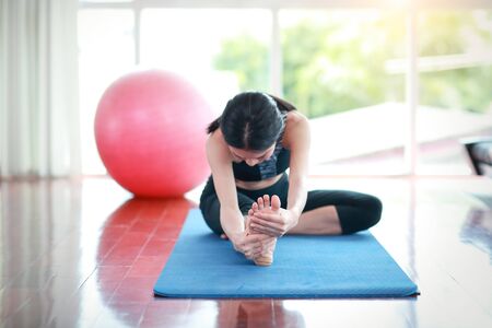 sporty girl practicing yoga and stretching in gymの写真素材