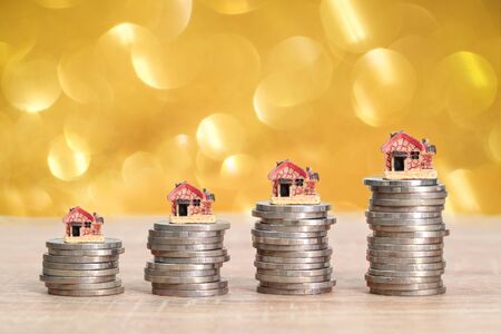 house on stack coins with yellow bokeh backgroundの写真素材