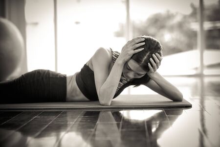 young healthy and sporty woman got headache and stress from too much exerciseの写真素材