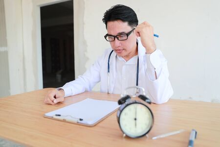 asian doctor portrait working and checking patient list (medical concept)の写真素材
