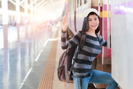 young traveler woman with backpack getting on the trainの写真素材