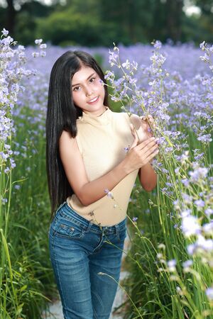 portrait of beautiful woman having a happy time and enjoying among flower Naga-crested field in natureの写真素材