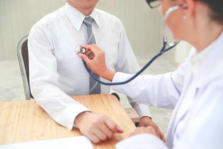 doctor checking male patient heart beatの写真素材