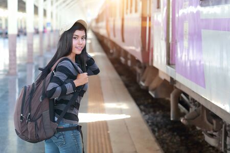 young traveler woman with backpack waiting for trainの写真素材