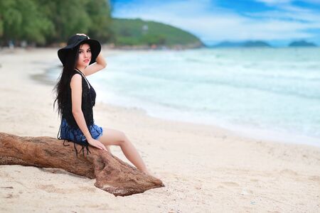 fashion and beautiful girl with black hat on the beachの写真素材