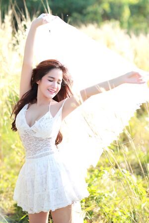 portrait of beautiful woman having a happy time and enjoying among grass field in natureの写真素材